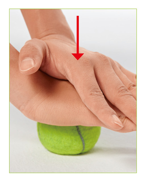 用手按壓網球時，雙手手掌交疊，力量更集中。