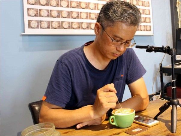 54歲陳明雄從小愛畫畫，用咖啡作畫讓他一炮而紅，7年間已畫了近萬杯咖啡畫。 記者...