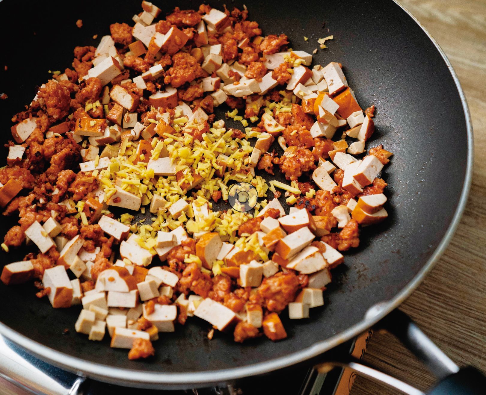 放入豆乾、素雞、薑末炒香,炒香後再放入香菇丁煸至金黃。